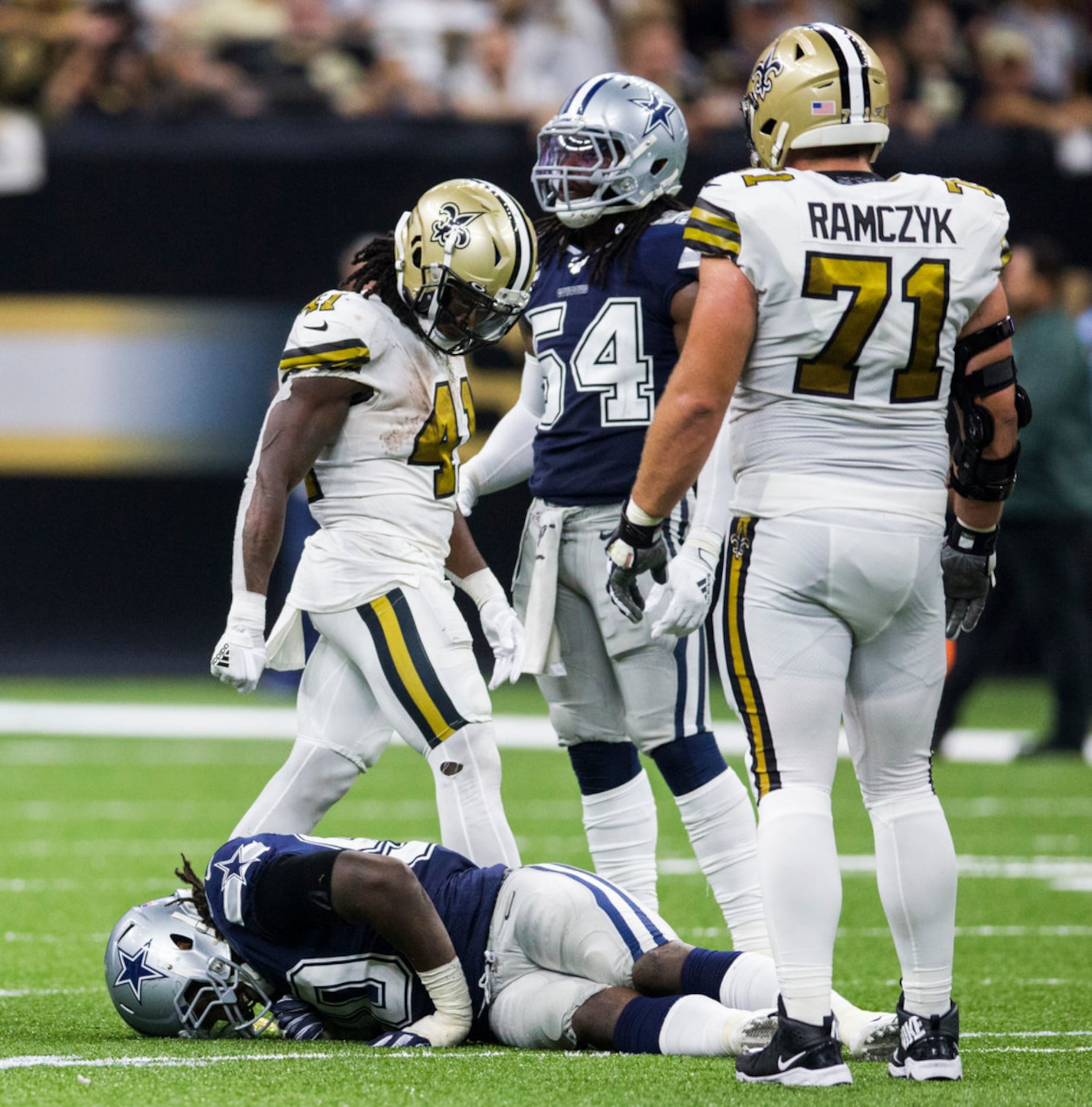 Dallas Cowboys defensive end Demarcus Lawrence (90) lays on the ground after a play with an...