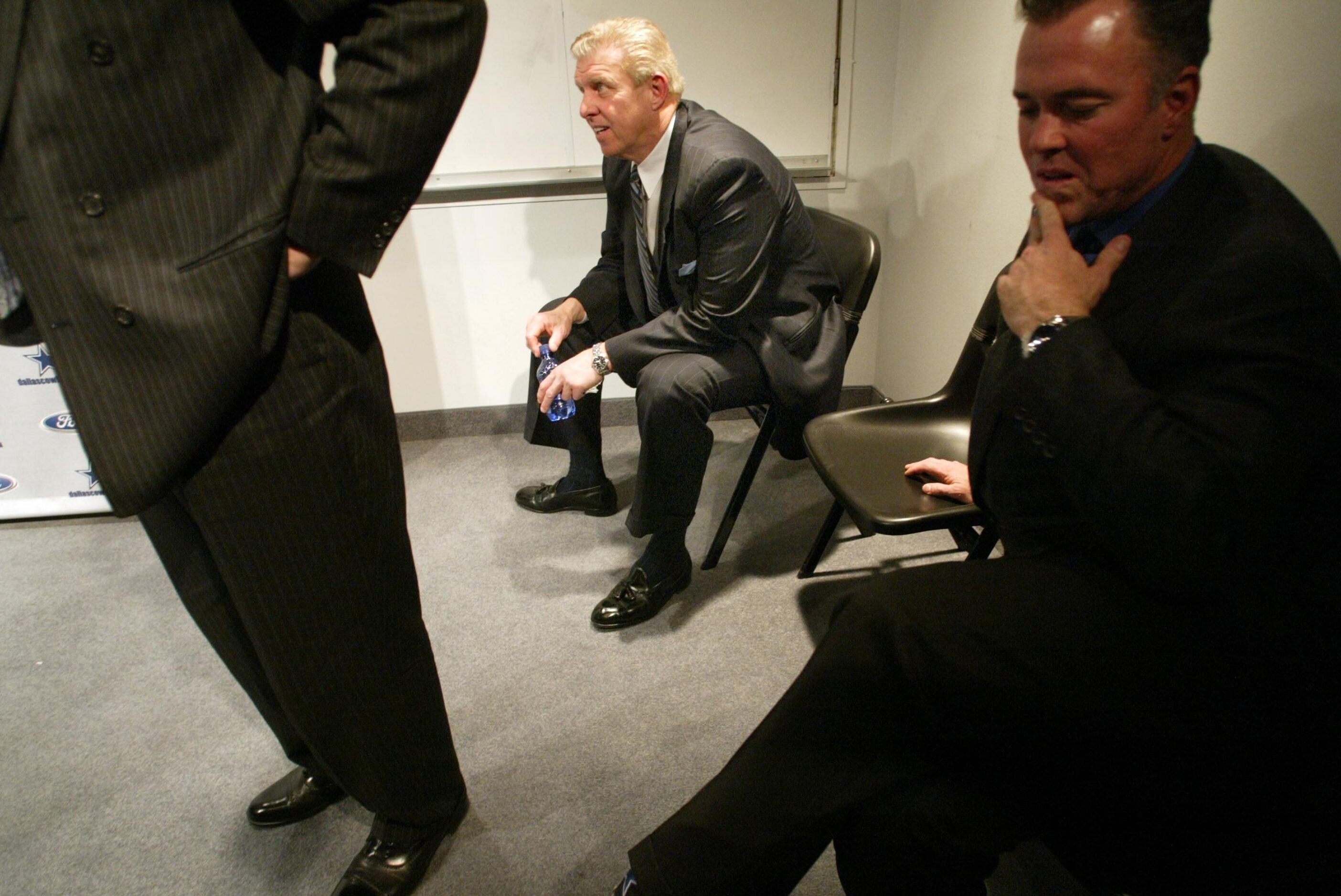 Newly hired Dallas Cowboys head coach Bill Parcells (center) listens in on Jerry Jones...