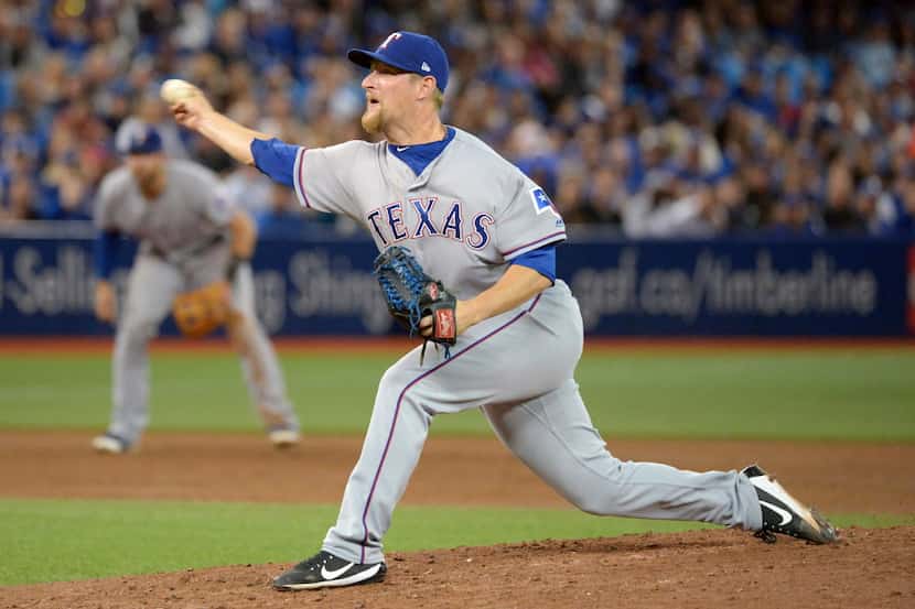 Texas Rangers' Austin Bibens-Dirkx pitches against the Toronto Blue Jays during third-inning...