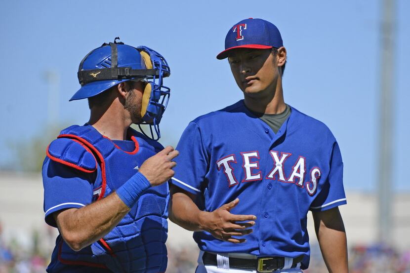 Mar 16, 2014; Surprise, AZ, USA; Texas Rangers starting pitcher Yu Darvish (11) talks with...