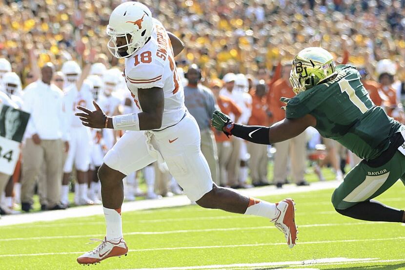 Texas quarterback Tyrone Swoopes (18) gets away from Baylor Taylor Young on the way to score...