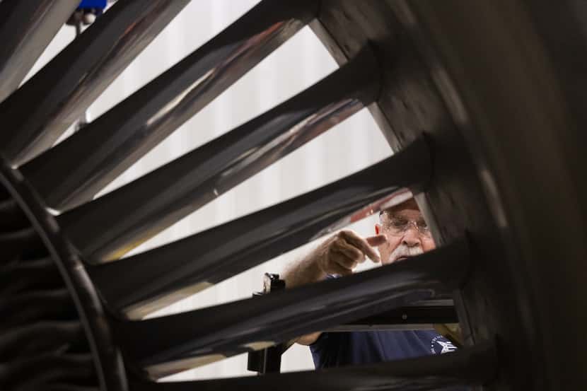 Aircraft maintenance technician’s Kirt Warner works on a Boeing 787’s GEnx engine at the...