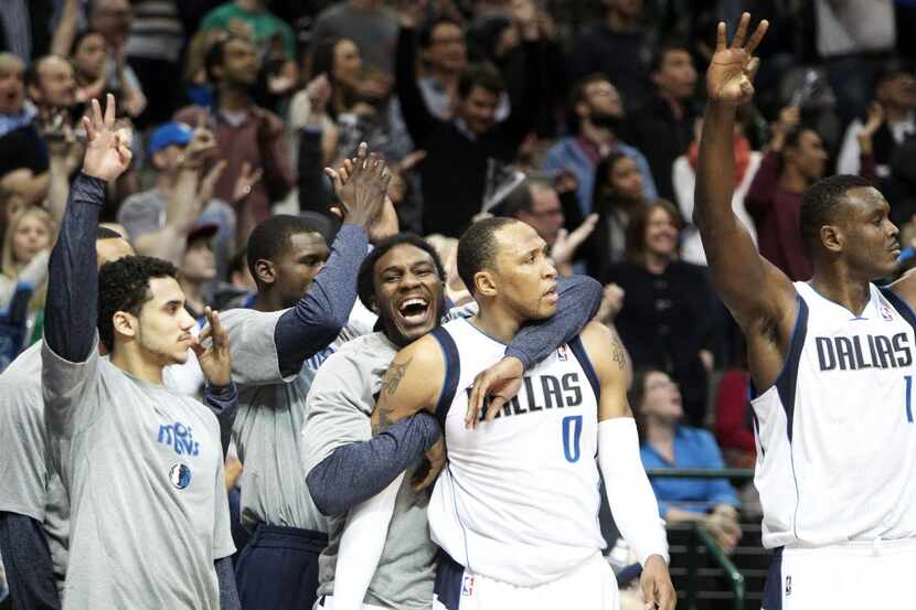 The Mavericks bench, including Shawn Marion (0) , celebrate after a three-pointer by Dallas...