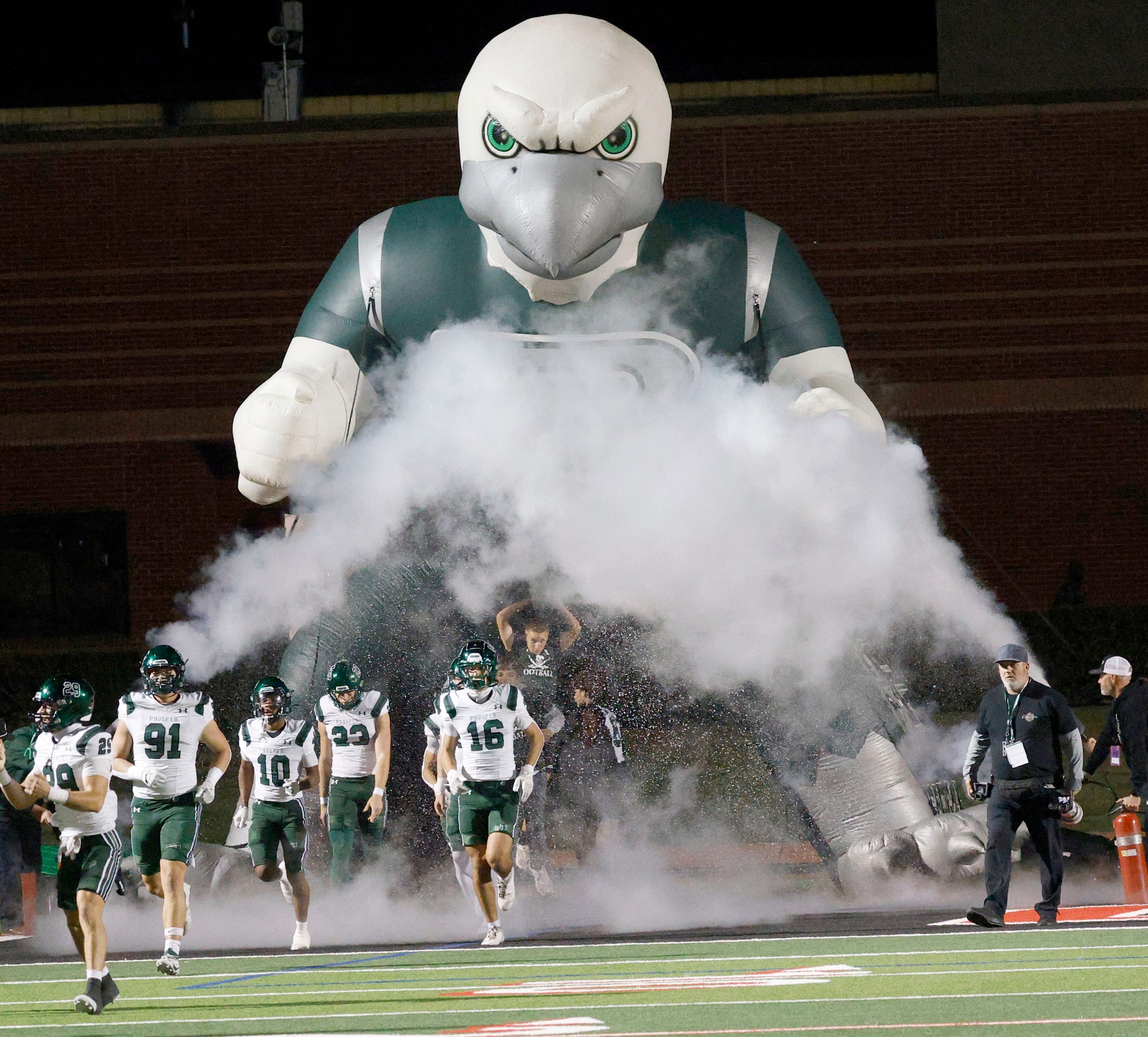 Prosper players run out to the field before before a high school football game against...