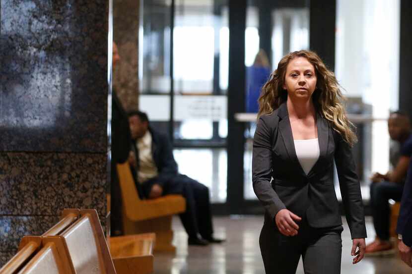 Former Dallas police Officer Amber Guyger (left) walks the hallway on her for court date at...