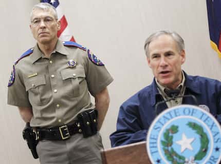 Texas Department of Public Safety Director Steve McCraw stands behind Gov. Greg Abbott. They...