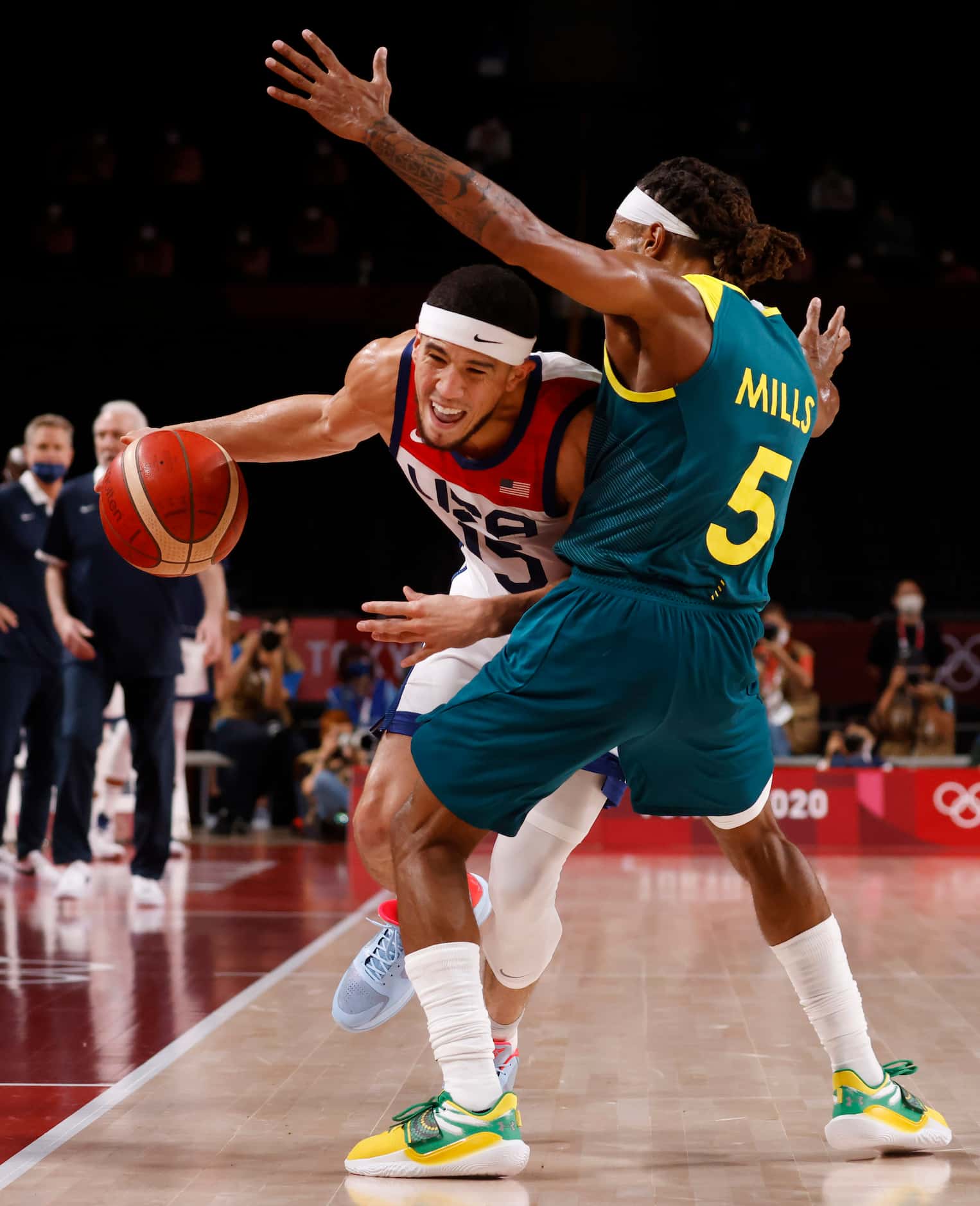 USA’s Devin Booker is fouled by Australia’s Patty Mills (5) during the second half of a...