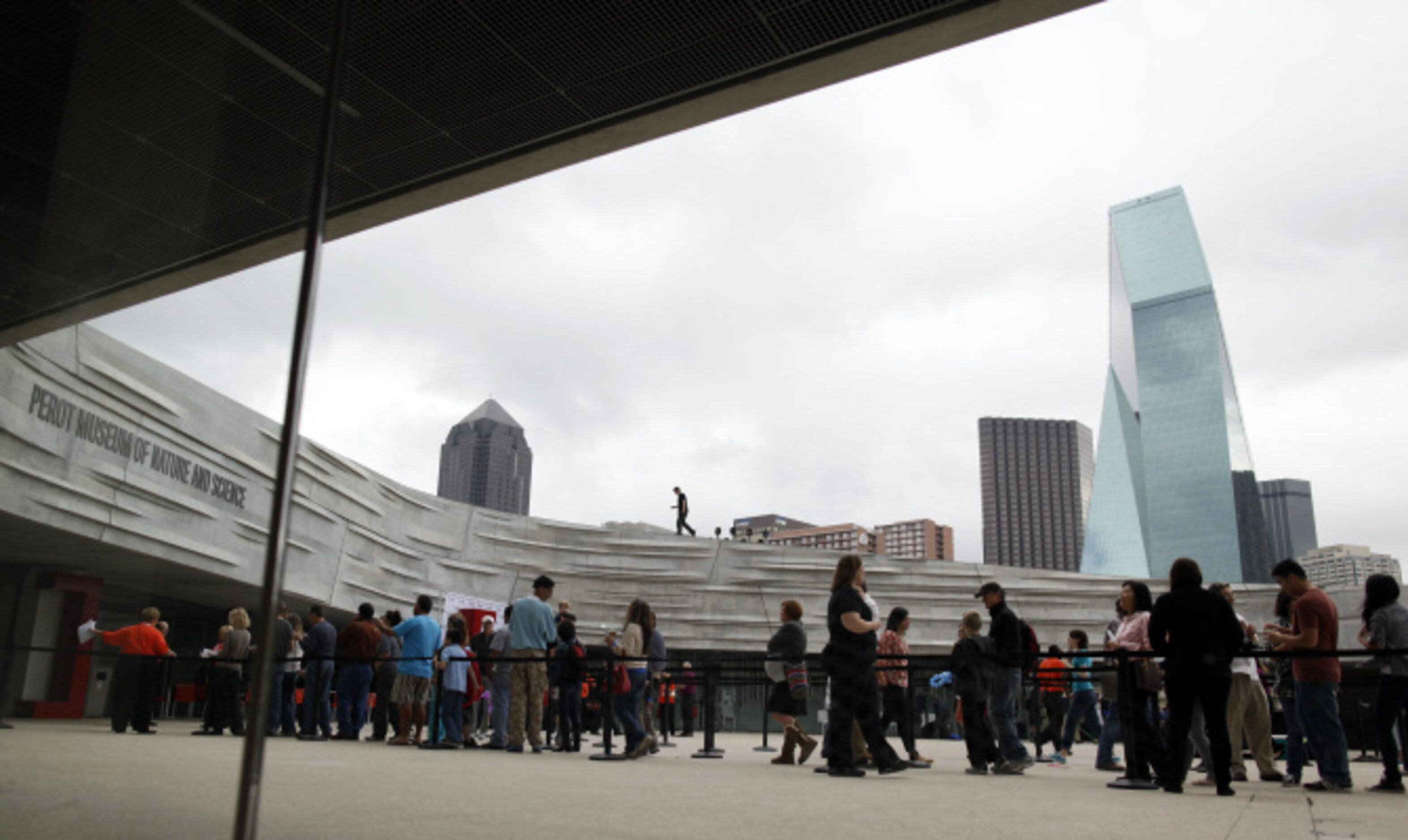 Visitors wait in line to enter into the Perot Museum of Nature and Science on opening day in...