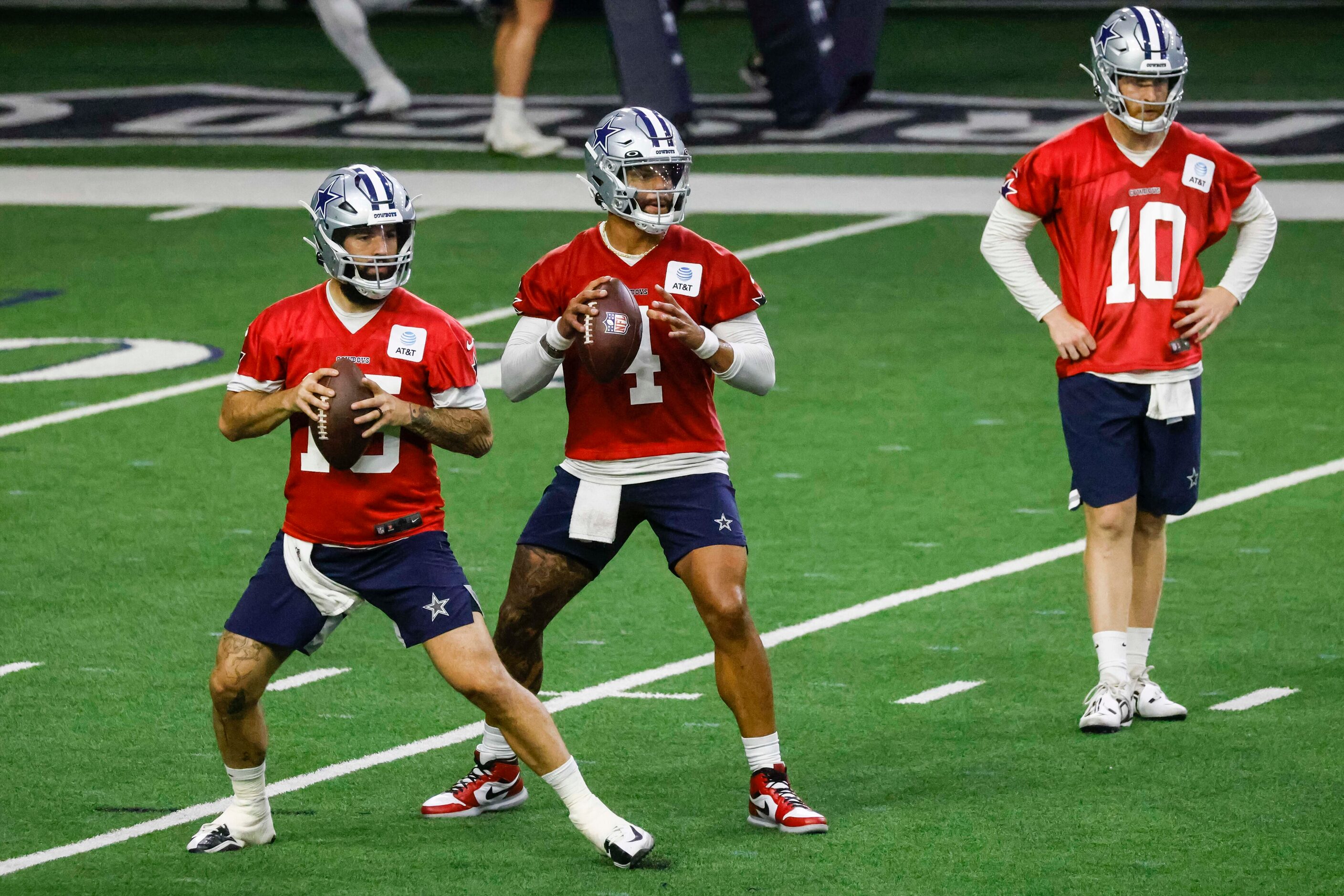 Dallas Cowboys quarterbacks Will Grier (left) and Dak Prescott (center) throw the ball as...