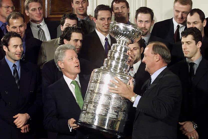 US President Bill Clinton (L) holds the Stanley Cup with the 1999 National Hockey League...