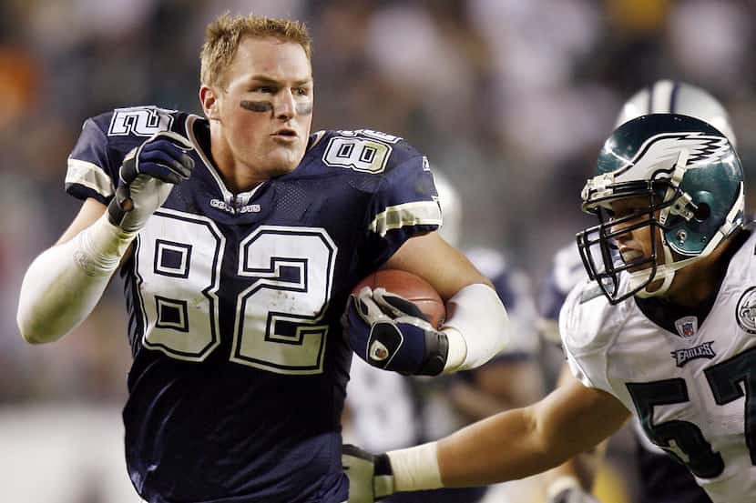 Dallas Cowboys tight end Jason Witten drives on without a helmet for extra yardage as Eagles...