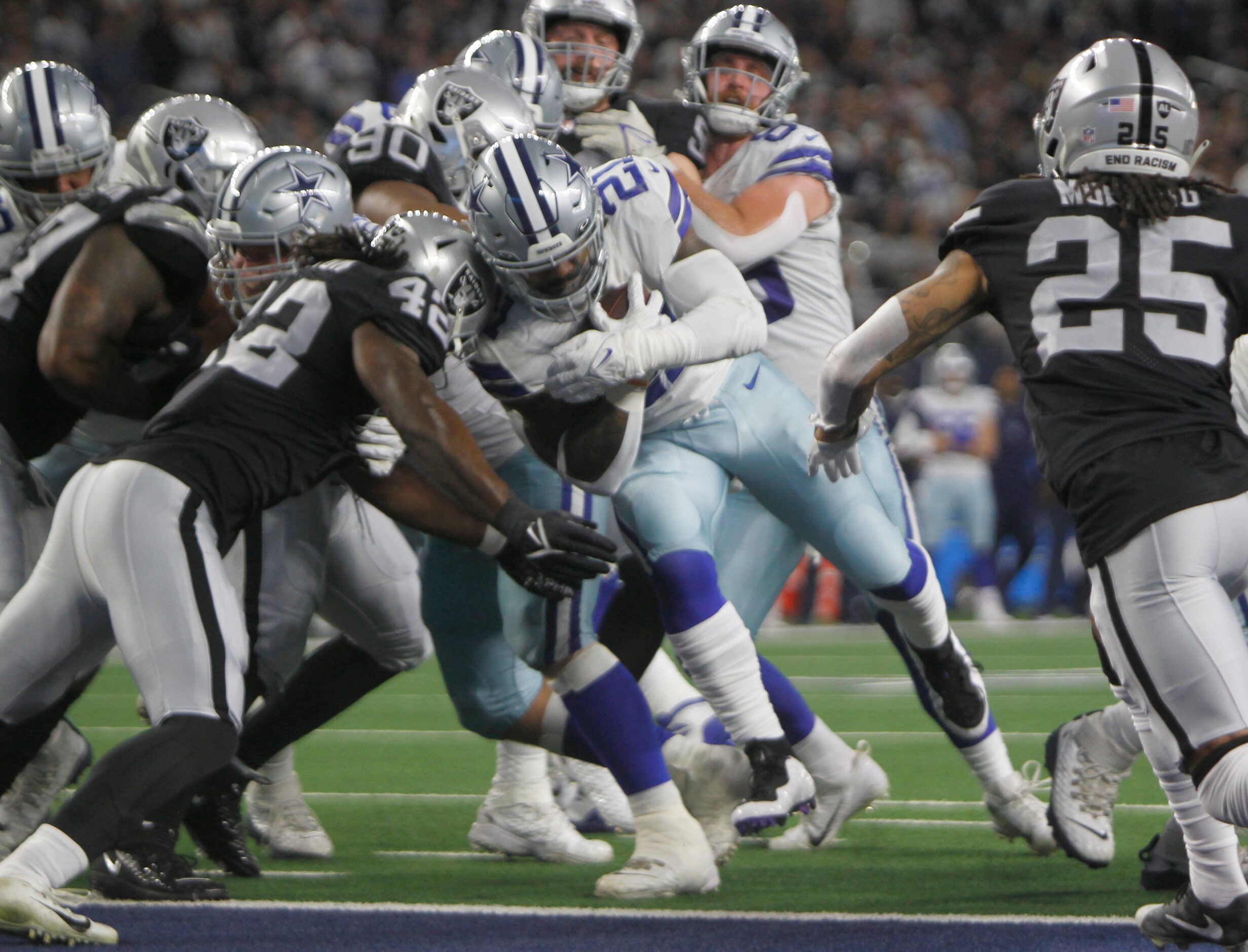 Dallas Cowboys running back Ezekiel Elliott (21), powers his way past Las Vegas Raiders...