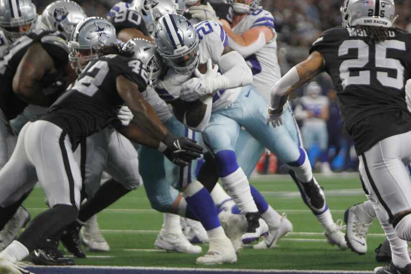 Dallas Cowboys running back Ezekiel Elliott (21), powers his way past Las Vegas Raiders...