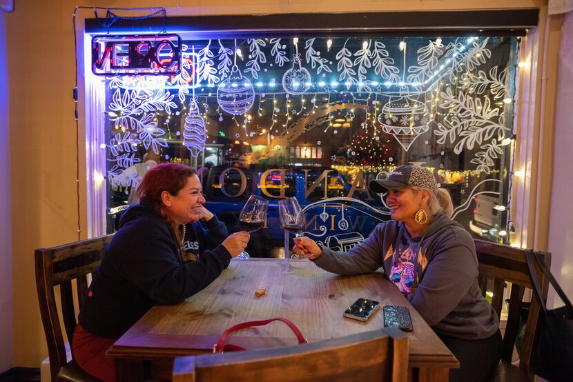 Elaine Lafon, left, of Dallas, and Mayra Villalobos, of Grapevine, enjoy glasses of wine at...