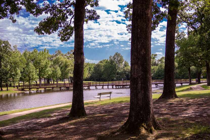 A shot of a park and a park bench near a lake in Mount Pleasant, TX.