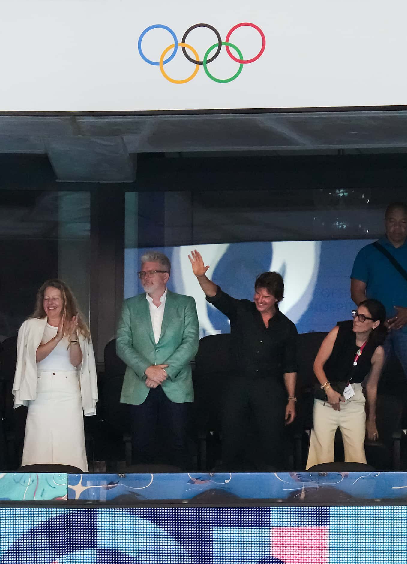 Actor Tom Cruise (center, right) waves to the crowd as he watches swimming with director...