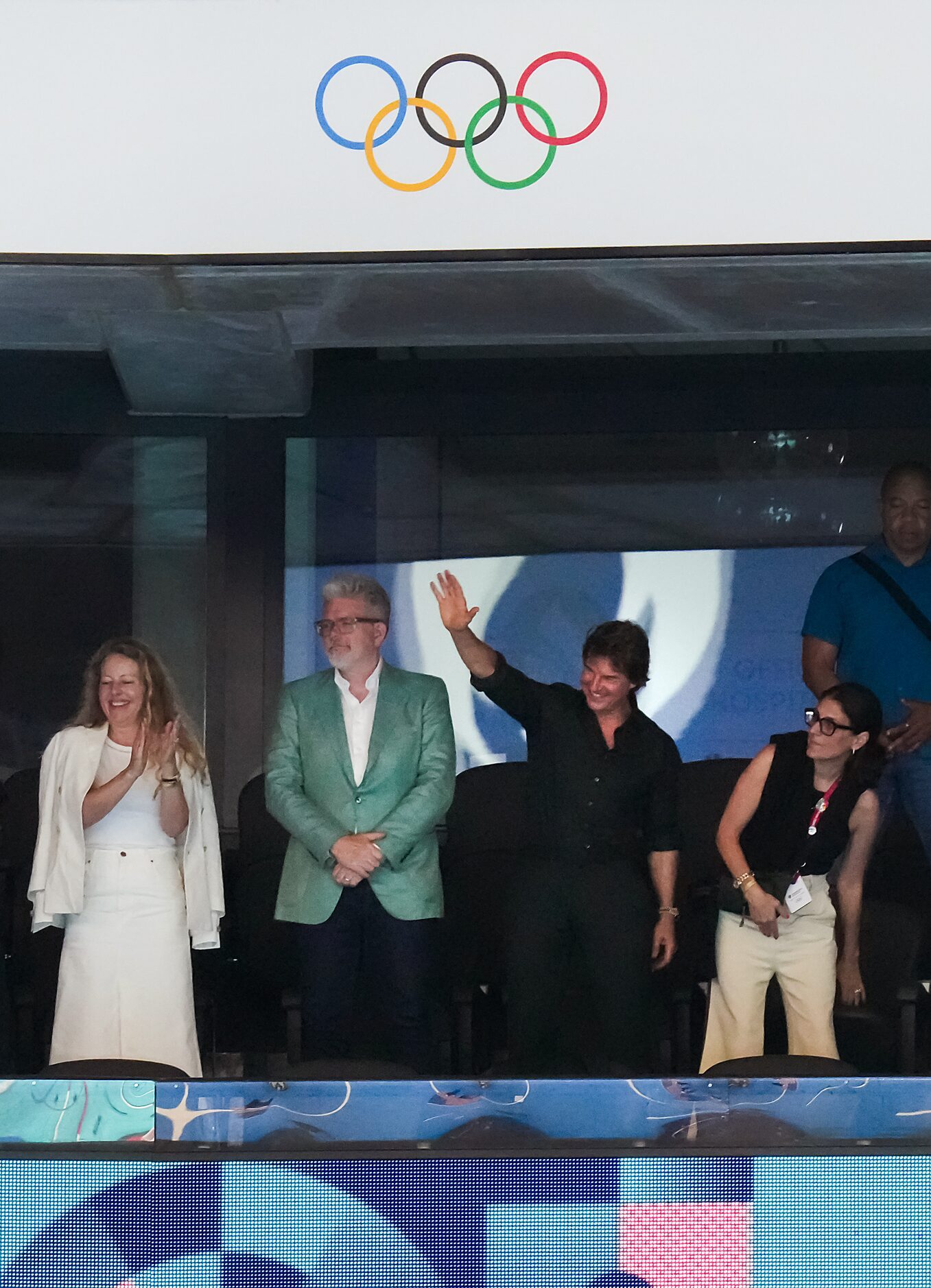 Actor Tom Cruise (center, right) waves to the crowd as he watches swimming with director...