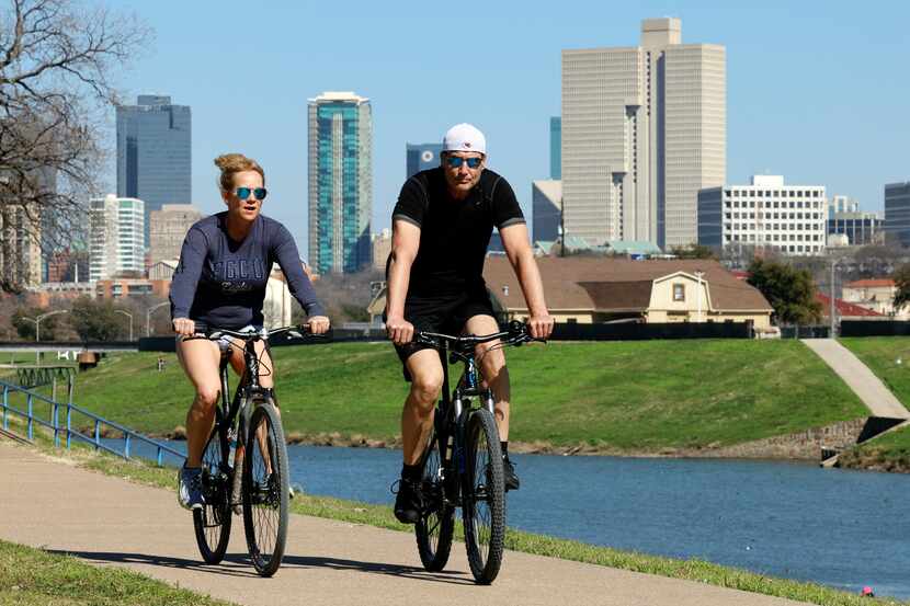 People ride their bike along the Trinity River at Trinity Park, Wednesday, Feb. 21, 2024, in...