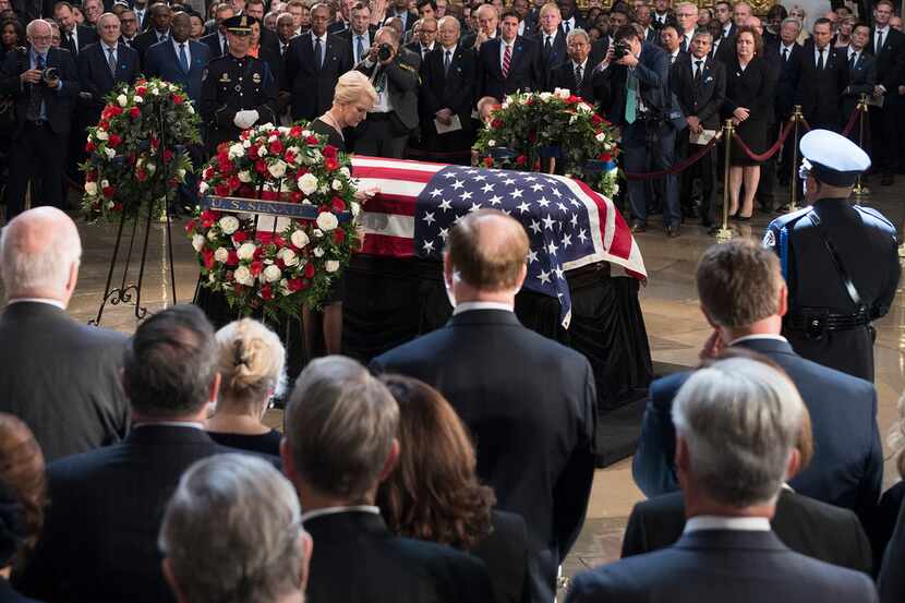 Cindy McCain stands beside the flag-draped casket bearing the remains of her husband, Sen....