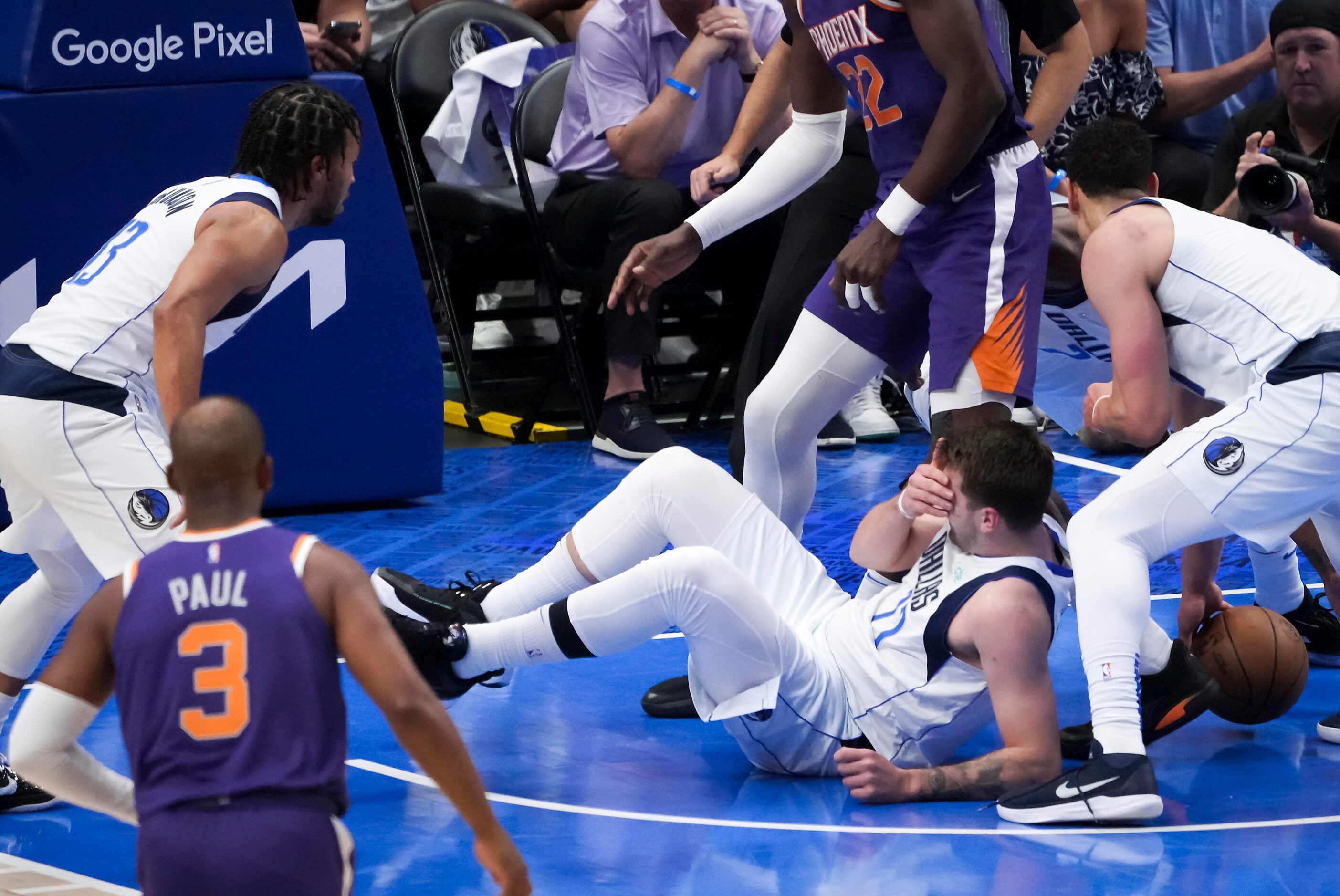 Dallas Mavericks guard Luka Doncic (77) grabs his face during a loose ball scramble during...