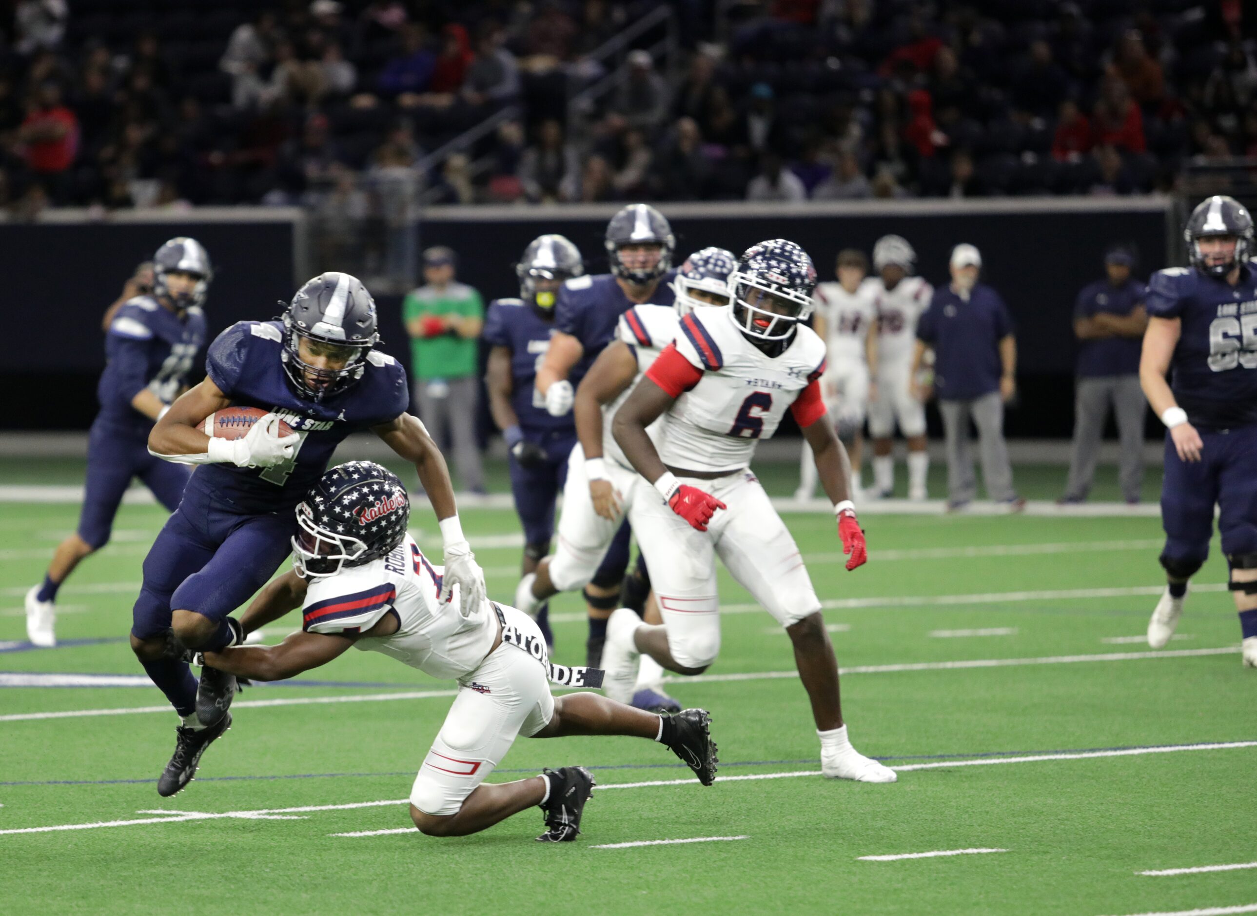 Lone Star player #4, Jaylon Braxton, tries to break a tackle by Ryan player #7, Garyreon...