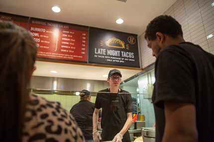 Anthony Parnell serves customers at Chipotle as the company launched its $2 tacos. Most...