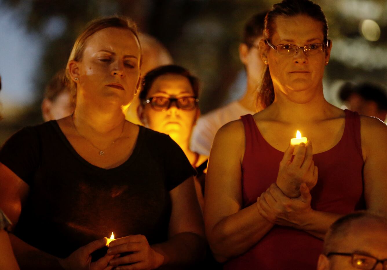 Leslie Decker (left) and Ashley Sheets attend a candlelight vigil in remembrance of Heather...