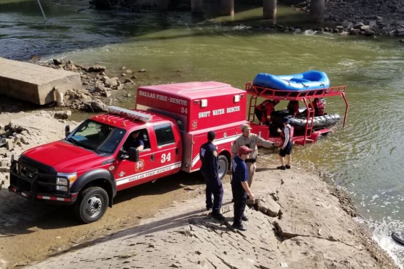 Rescue workers scan the Trinity River during efforts to pull a car from the river on Tuesday.