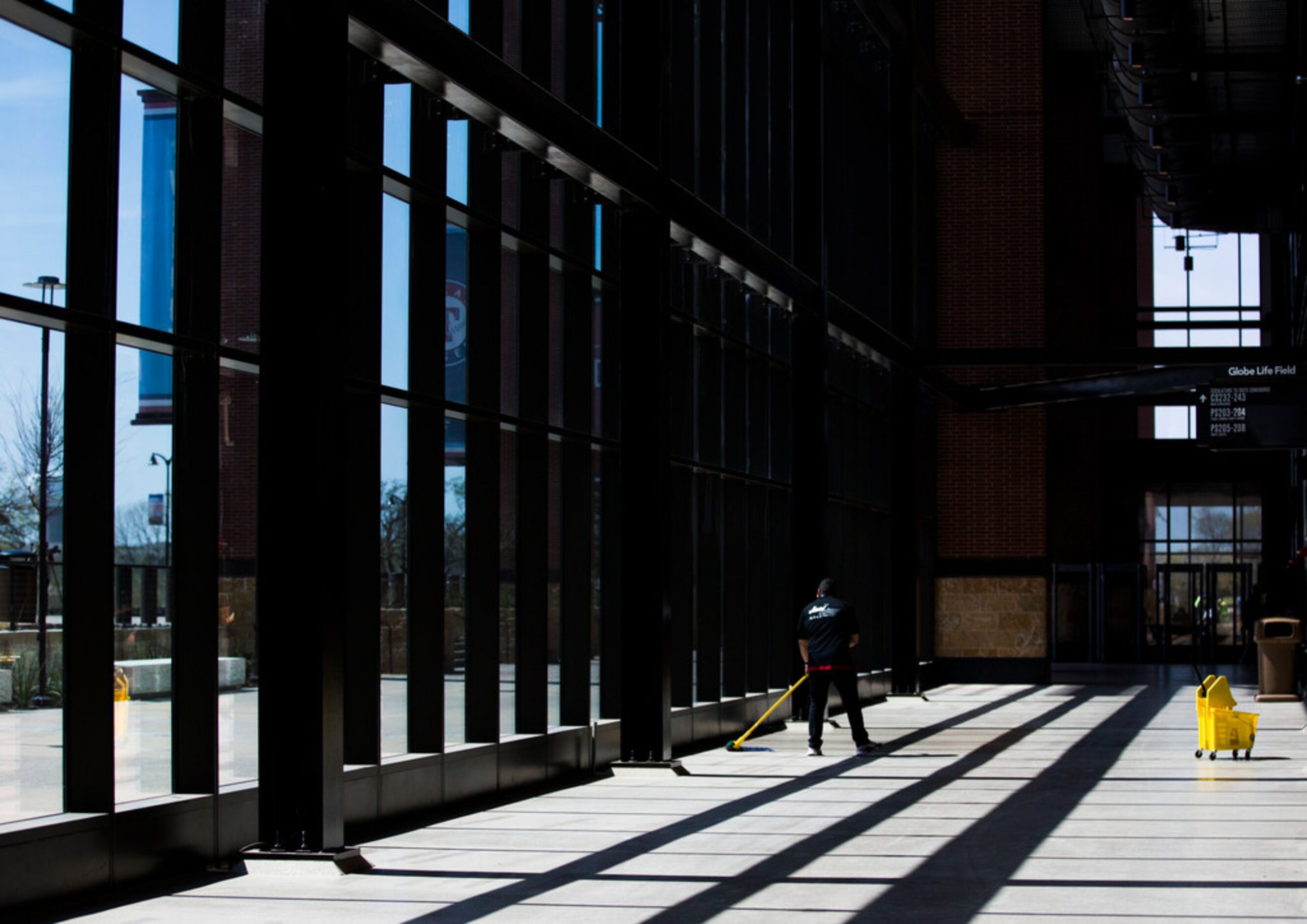 A worker mops the floor on the main concourse during an open house for the Texas Rangers'...