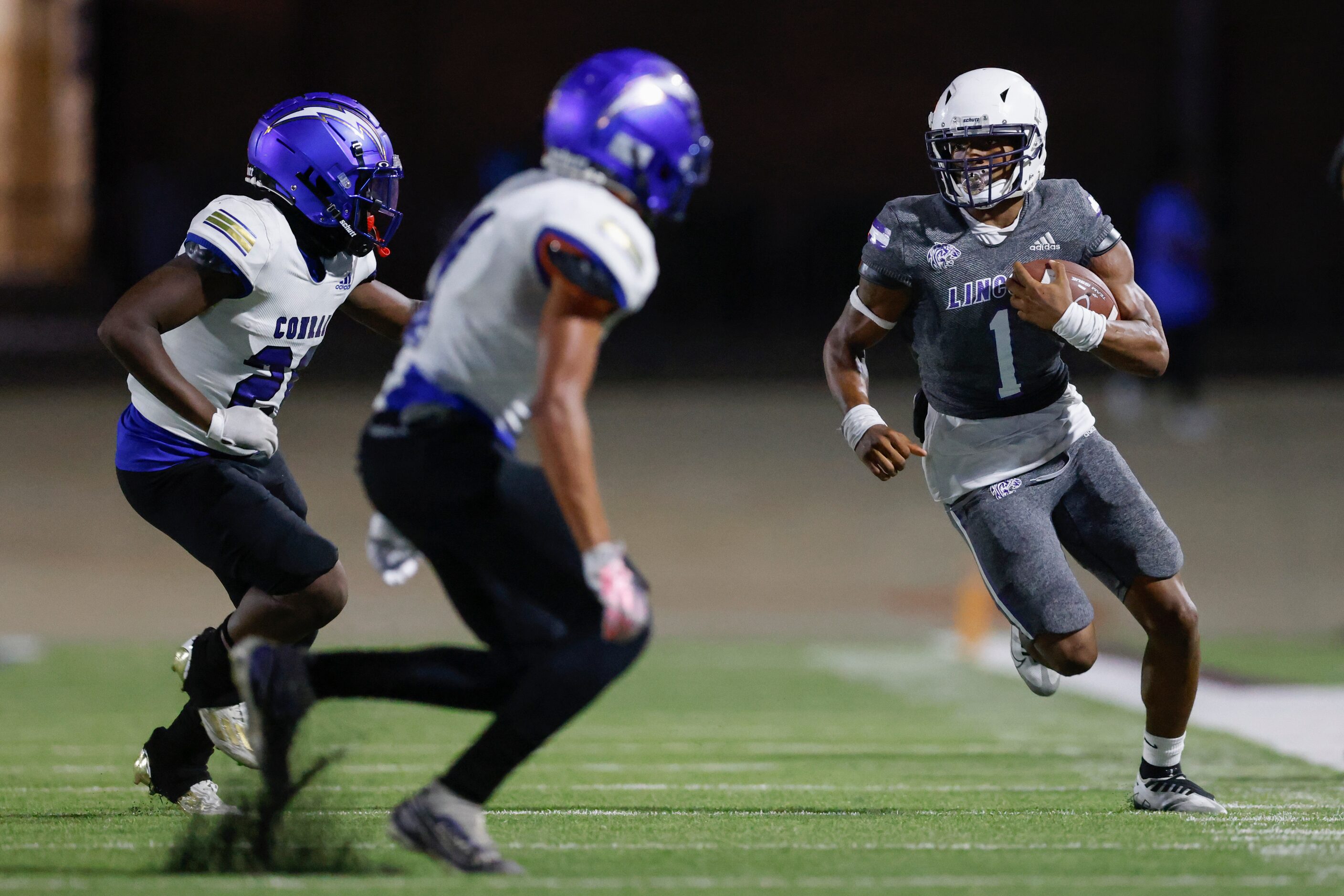 Lincoln running back Talan Beachum (1) runs down the sideline as a pair of Conrad defenders...