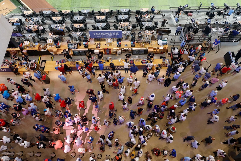 Fans walk around before the MLB All-Star baseball game at Globe Life Field, Tuesday, July...