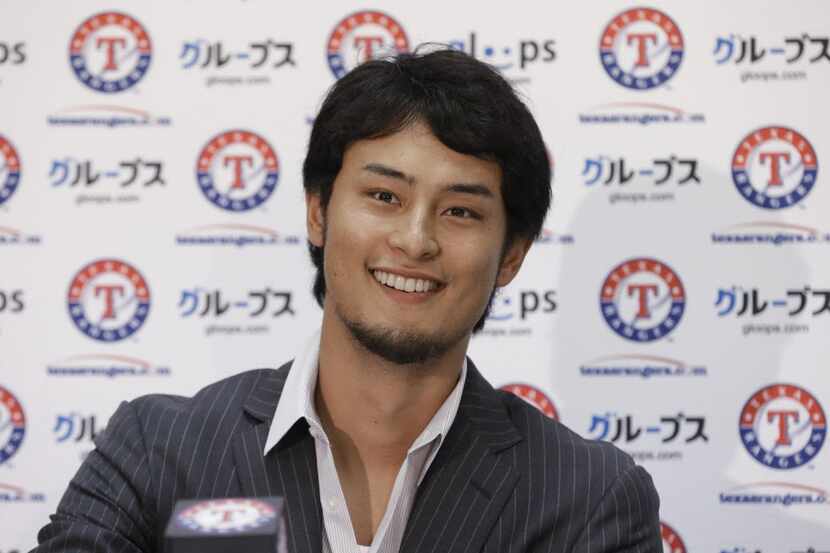 Texas Rangers pitcher Yu Darvish, of Japan, smiles as he arrives for a media availabilty at...