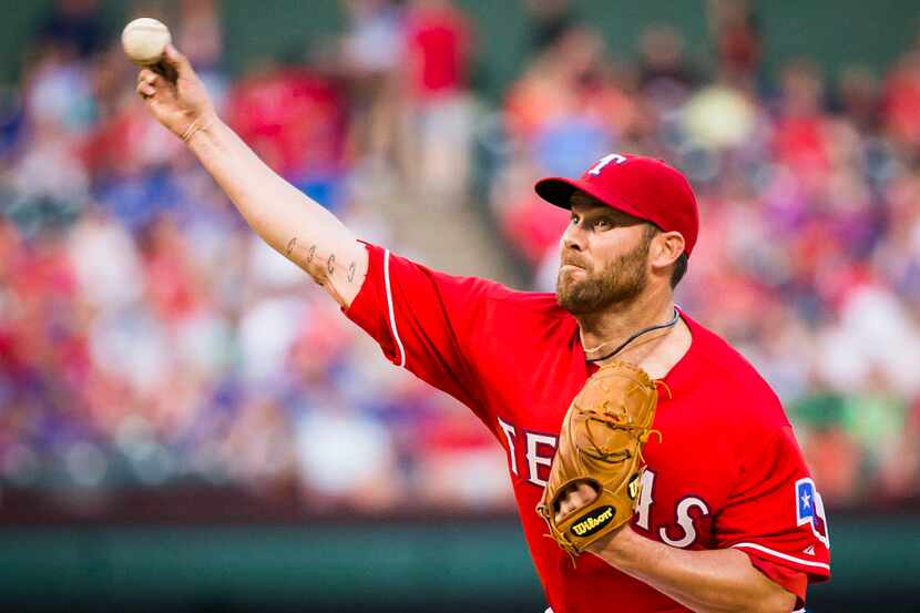 Texas Rangers starting pitcher Colby Lewis delivers a pitch during the second inning against...