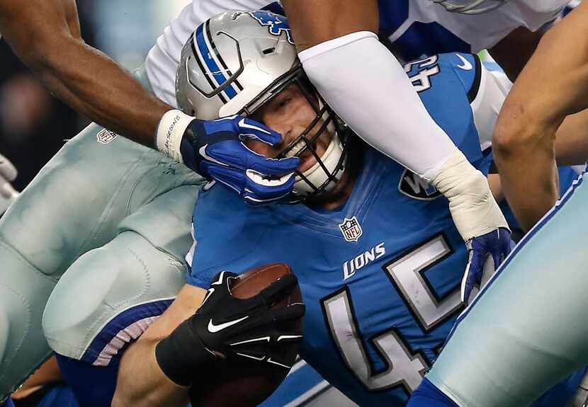 Detroit Lions fullback Jed Collins (45) is grabbed in the face mask by Dallas Cowboys...