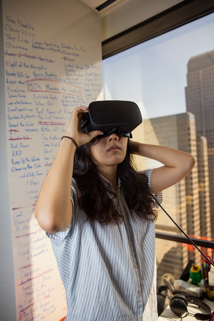 Ruby Wang, concept artist at Flight School Studio, wears a VR headset during a portrait...