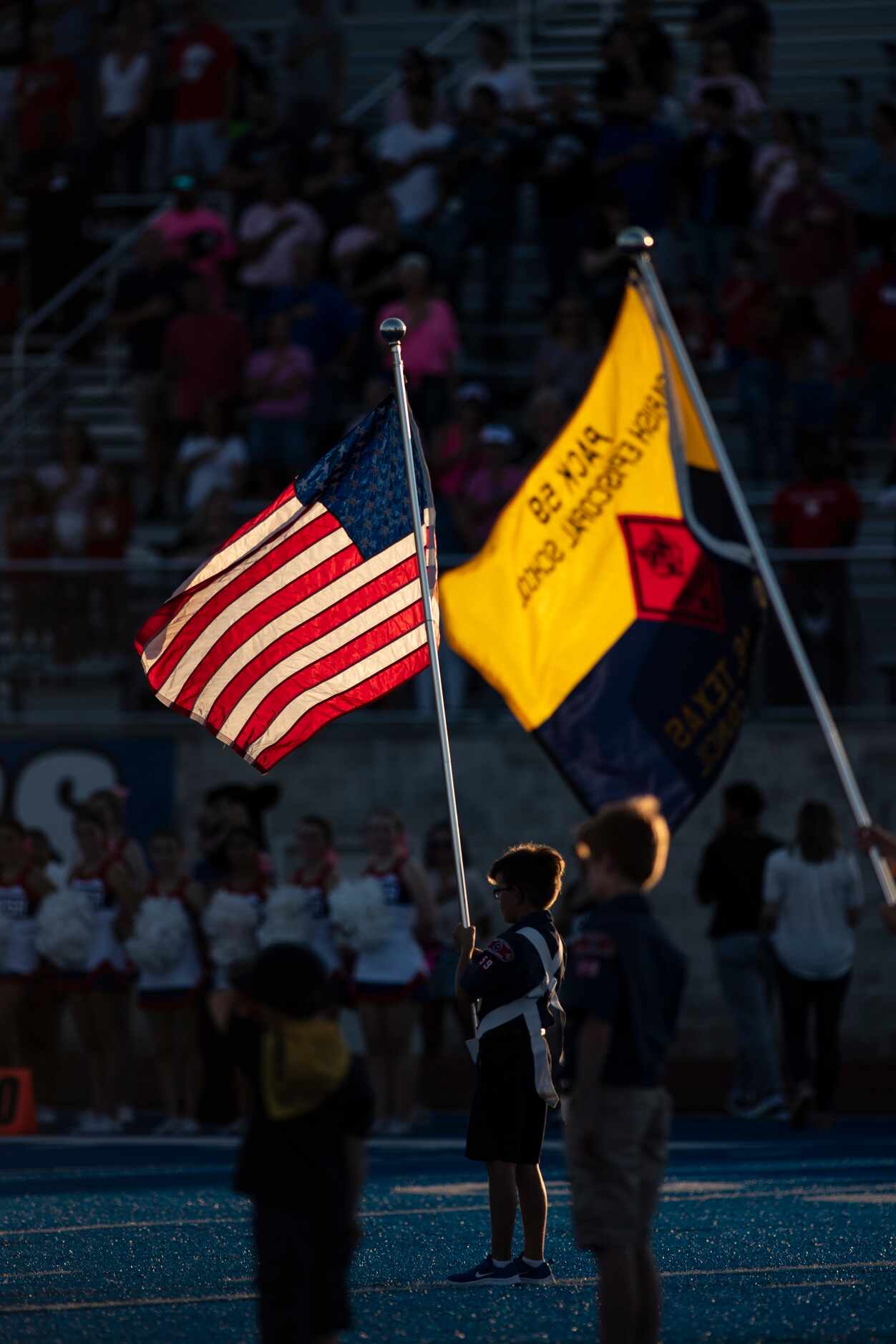 A Cub Scout holds the American flag prior to the start of Parish EpiscopalÕs home game...