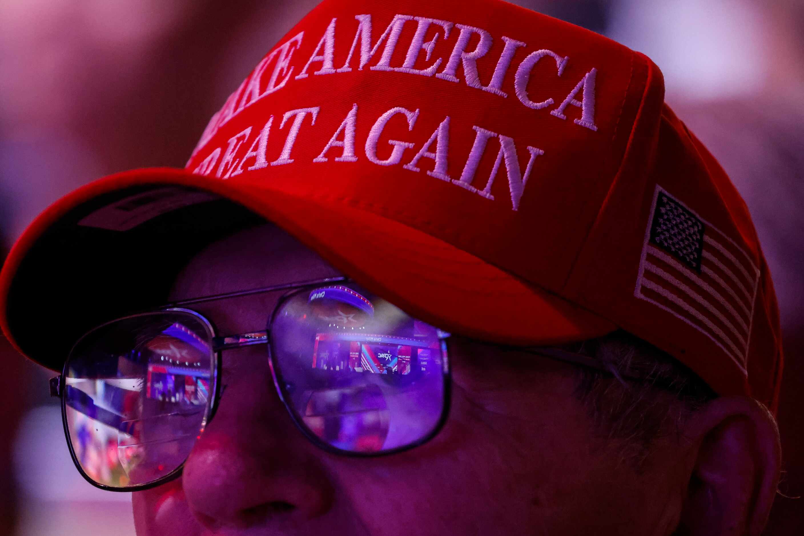 The main stage of CPAC is reflected on the spectacles of an attendee during the third day of...