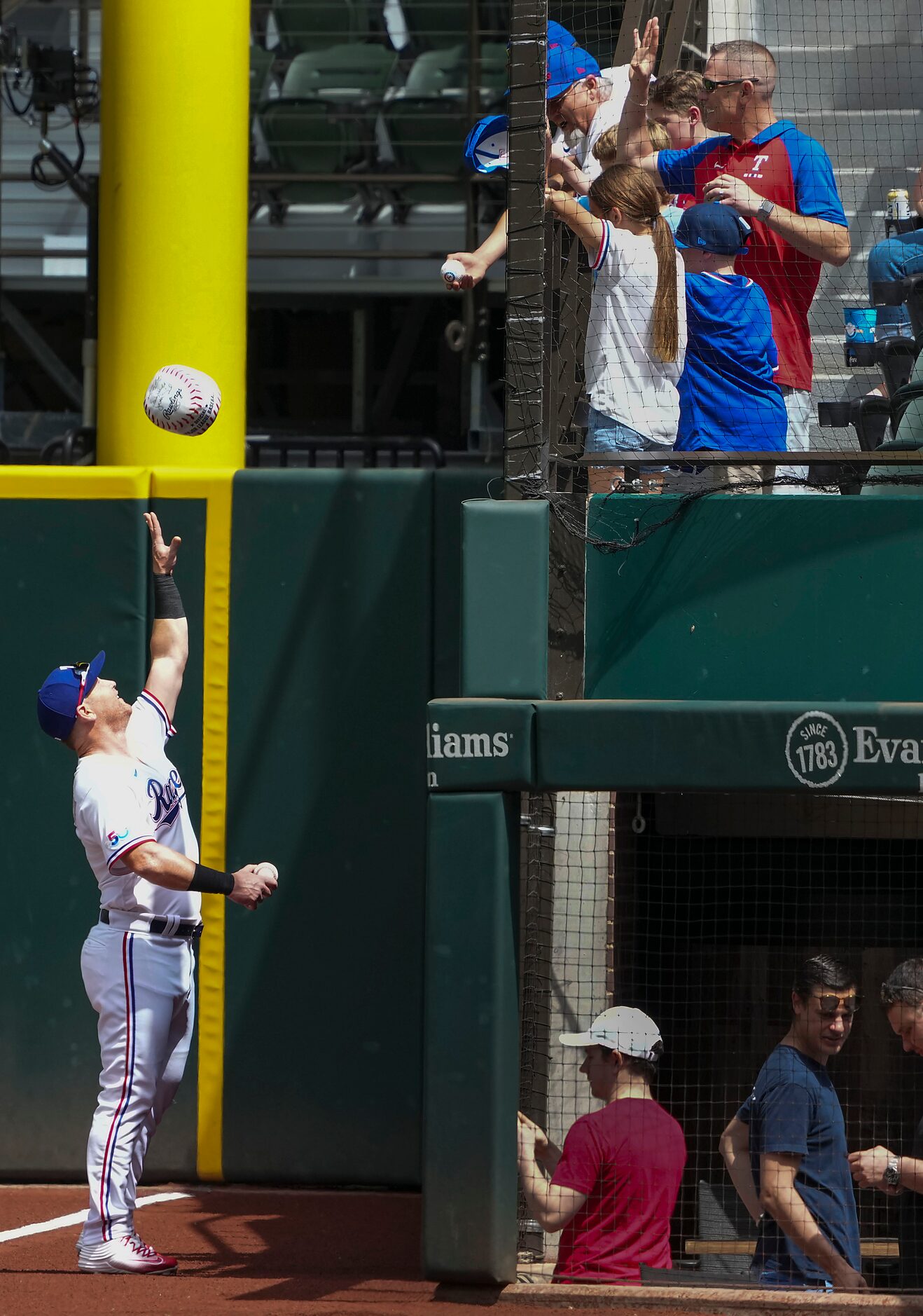 Texas Rangers right fielder Kole Calhoun tosses a ball to the crowd while signing autographs...