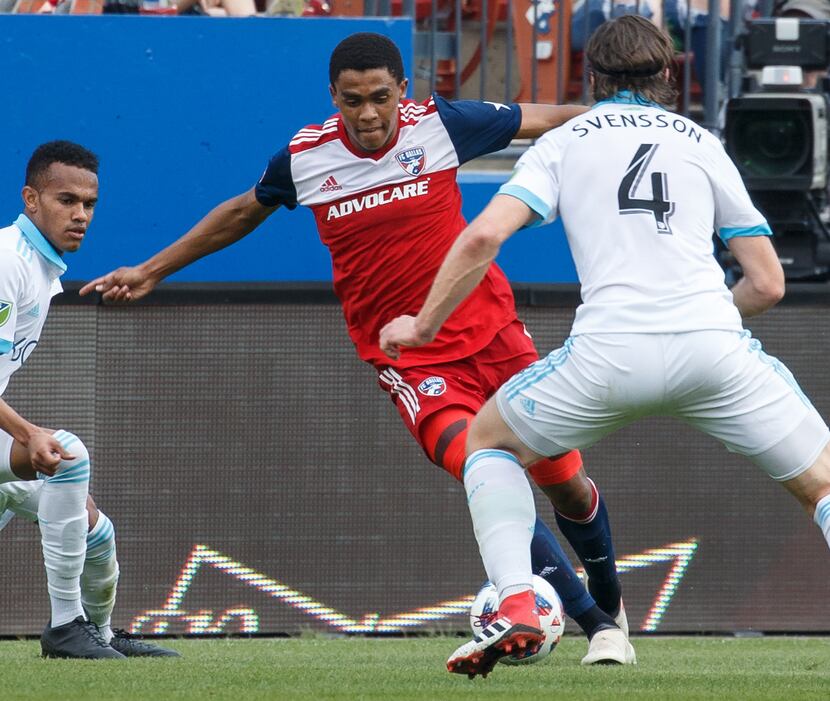 Reggie Cannon of FC Dallas attempts to dribble past Gustav Svensson of the Seattle Sounders....