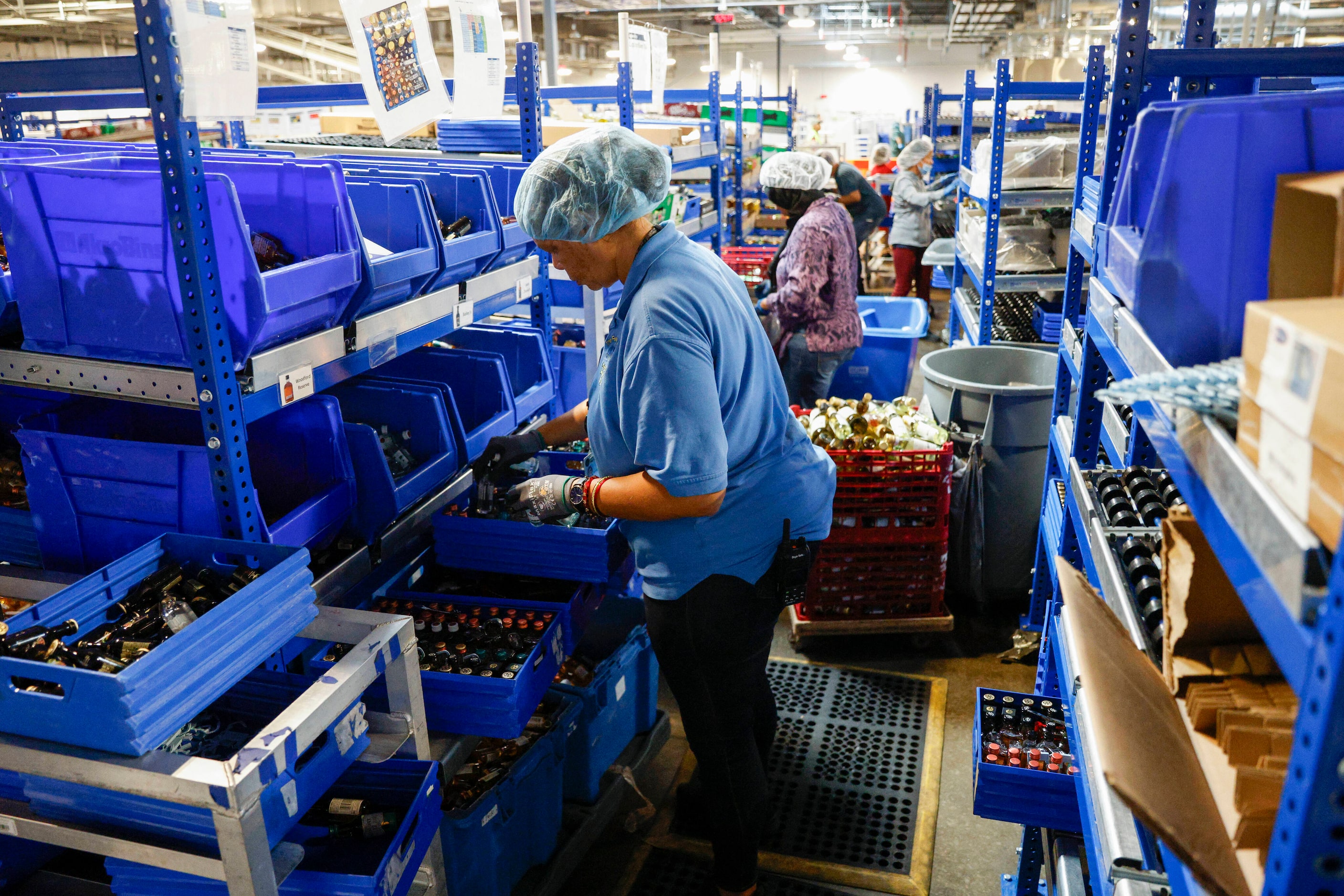 Ami Napier, operations supervisor for LSG Sky Chefs, sorts mini liquor bottles into trays...