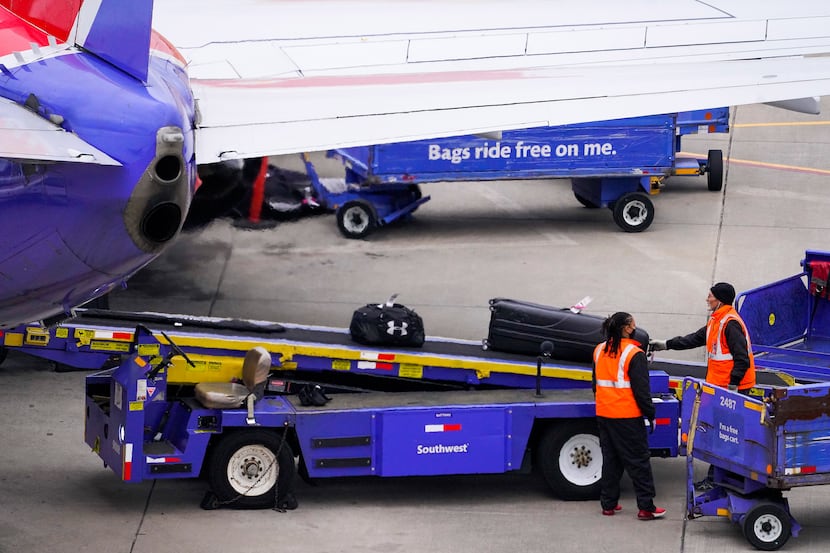 Baggage handlers unload a Southwest Airlines flight at Dallas Love Field on Thursday, Jan....