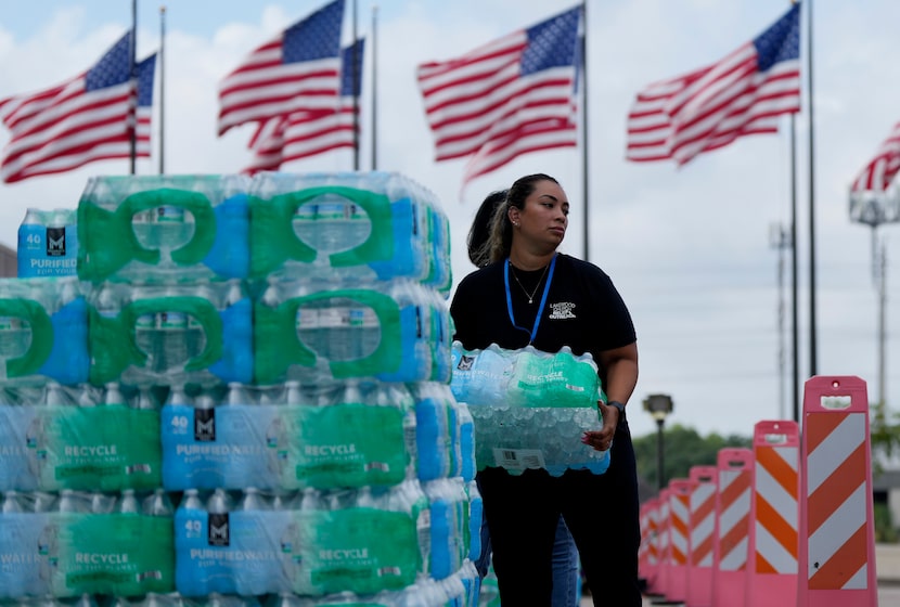 Staff at Lakewood Church hand out water and operate a cooling station in Houston, Tuesday,...