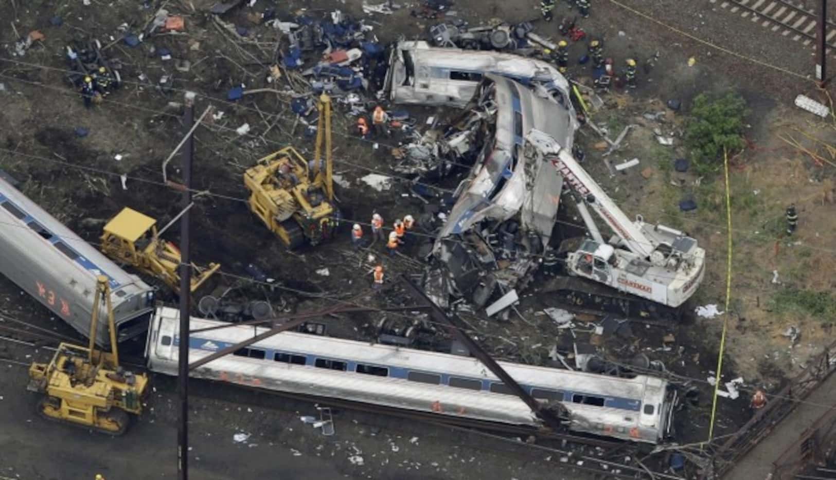 Una toma aérea muestra a personal de emergencia buscando entre los restos del tren que se...