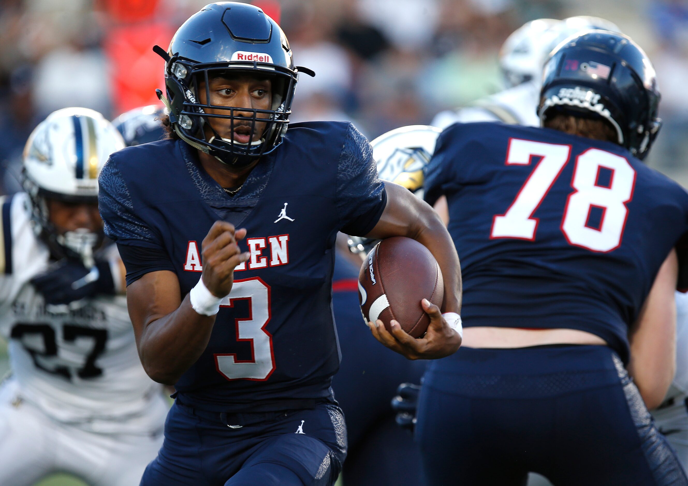 Allen High School quarterback Mike Hawkins (3) runs behind the block from Allen High School...