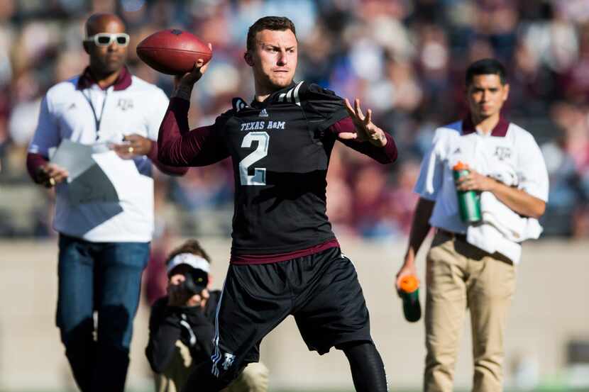 Former Texas A&M Aggies quarterback Johnny Manziel throws a pass to other former players...