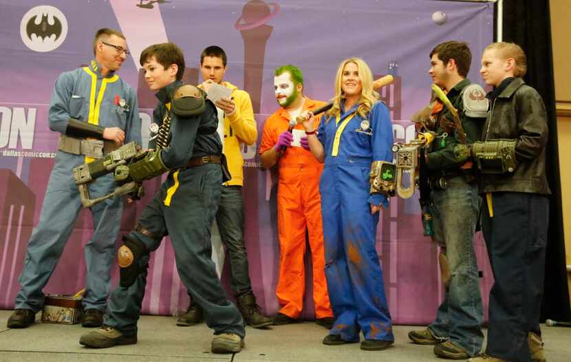 Actor Robbie Amell, background center, and emcee Ben Ambroso as The Joker are surrounded by...
