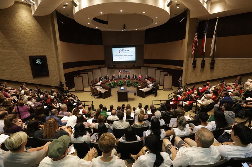 Community members listen during a City Council meeting at the Plano Municipal Center. Under...
