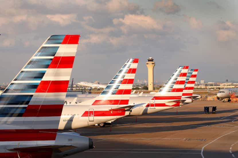 American Airlines jets are parked at Dallas-Fort Worth International Airport's Terminal C,...