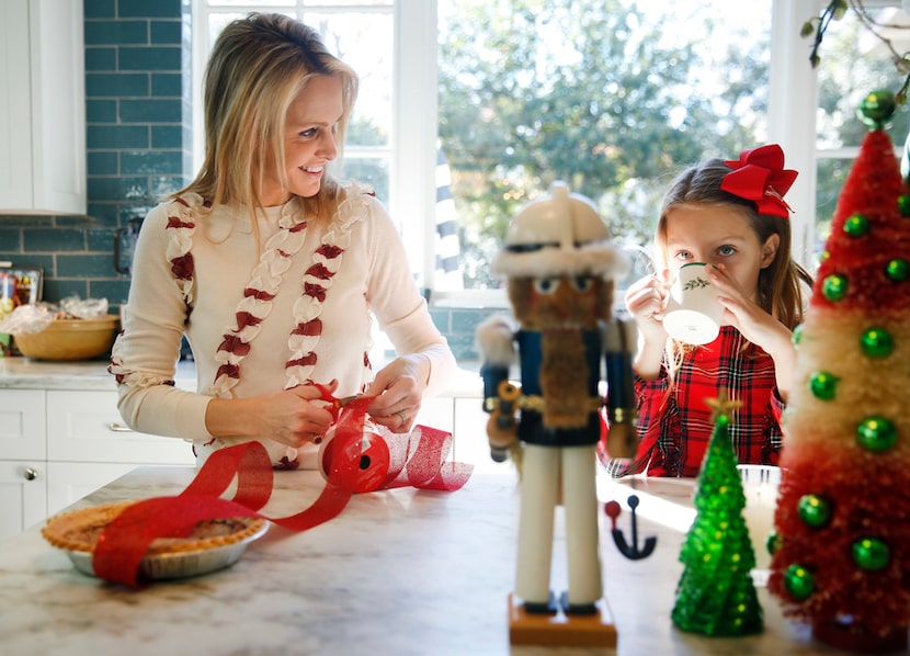 Meredith Land ties a Christmas ribbon around a pie her husband, Xan, made at their Dallas...