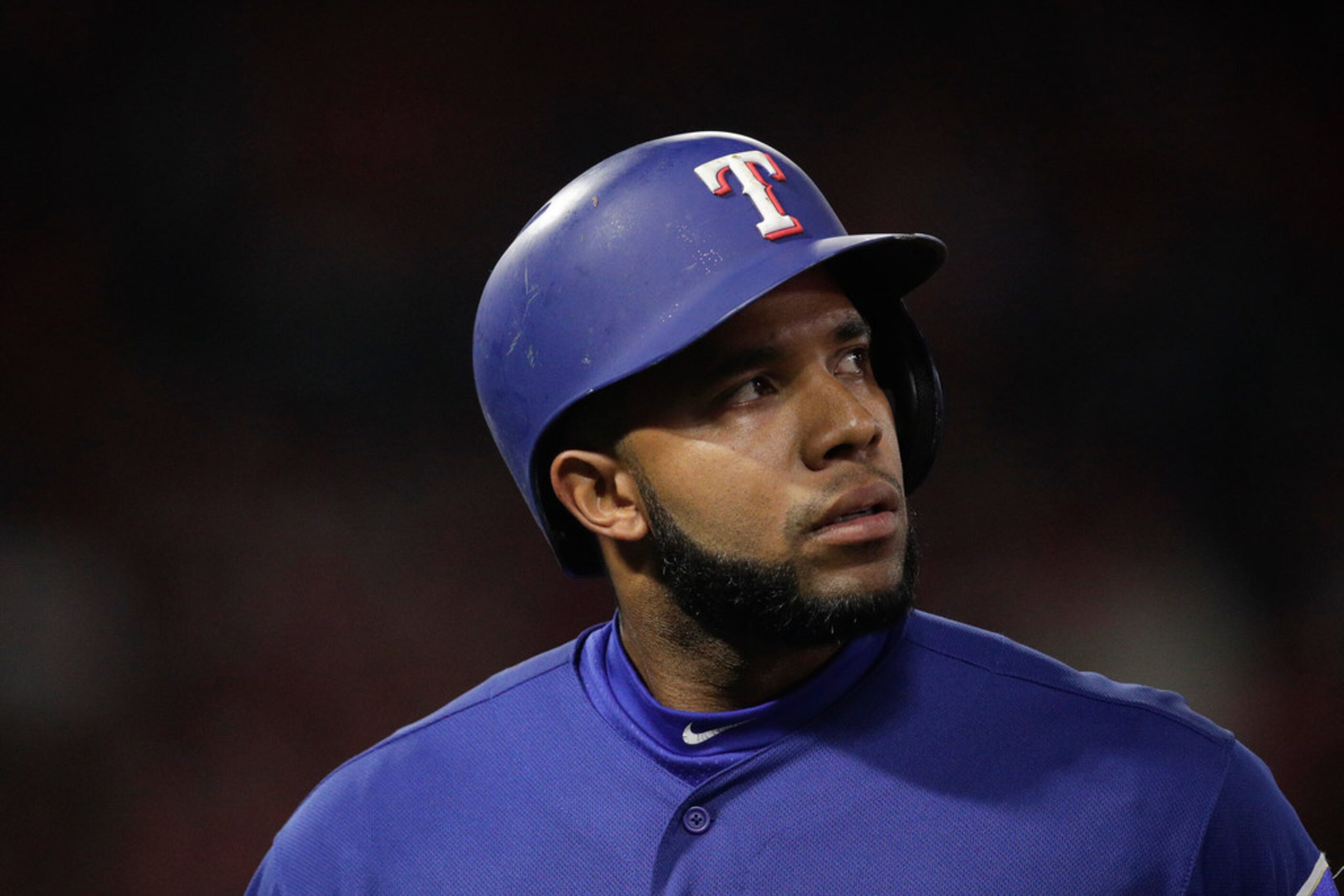 Texas Rangers' Elvis Andrus walks off the field after he flied out during the sixth inning...